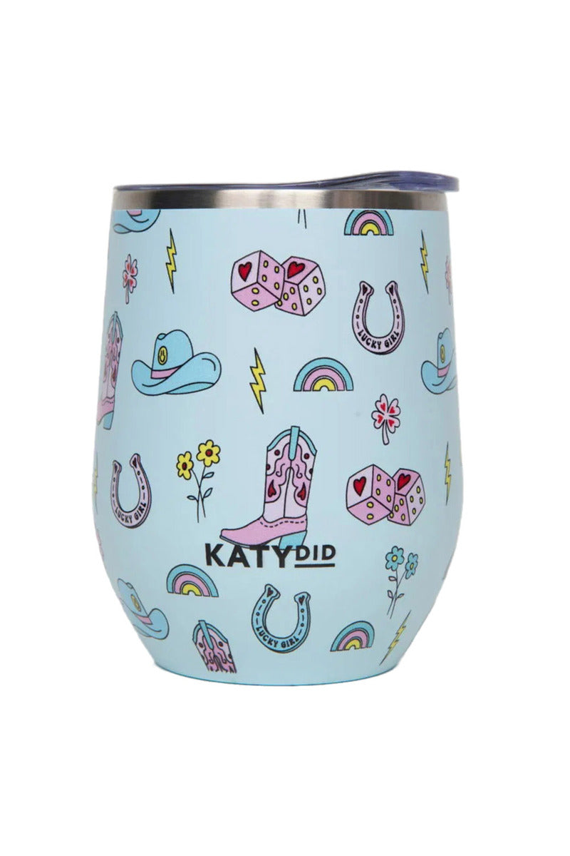 The Lucky Girl Western Insulated Wine Tumbler by Katydid features a light blue design with pink cowboy boots, hats, dice, horseshoes, rainbows, yellow flowers, lightning bolts, and KATYDID printed boldly on the front.