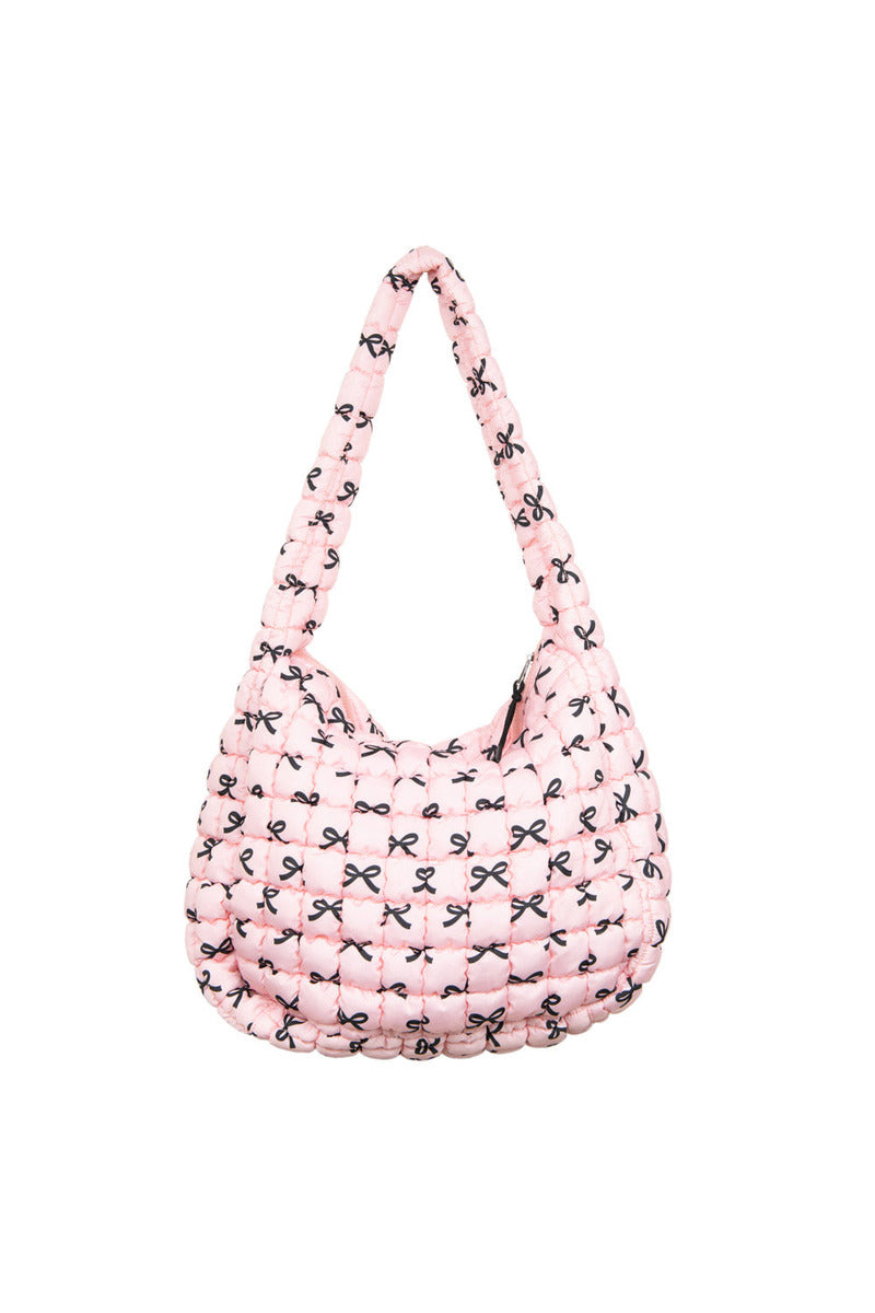 The Katydid Black  Pink Mini Coquette Bows Quilted Hobo Tote Bag features a soft pink quilted design, puffy strap, and repeating black bows for a charming, coquette-inspired style.