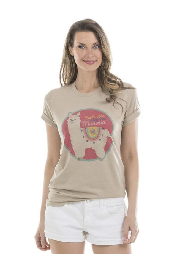 A woman with long brown hair wears the Katydid Fiesta Like There’s No Mañana Llama T-Shirt and white shorts, standing against a plain white background and smiling slightly.