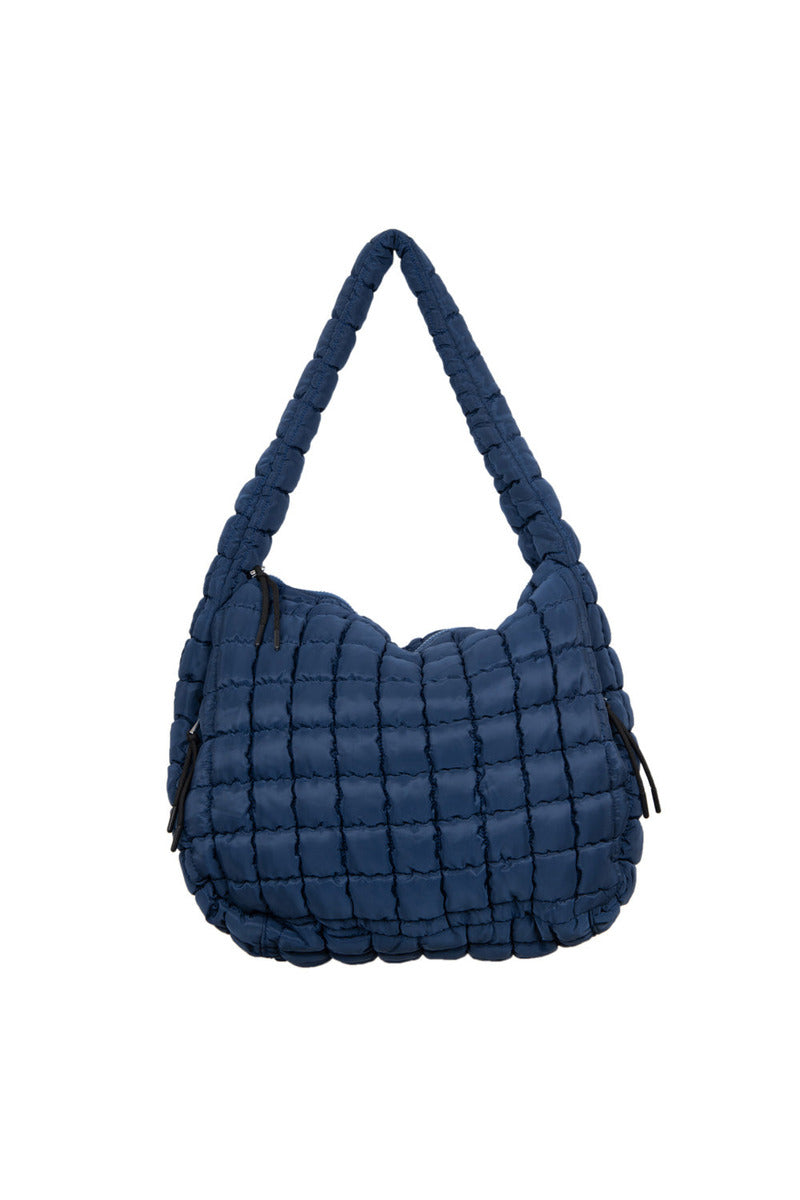 The Katydid Navy Oversized Quilted Hobo Tote Bag features a soft, puffy look with a grid-like quilted pattern, thick padded strap, side zippers, and a spacious design.