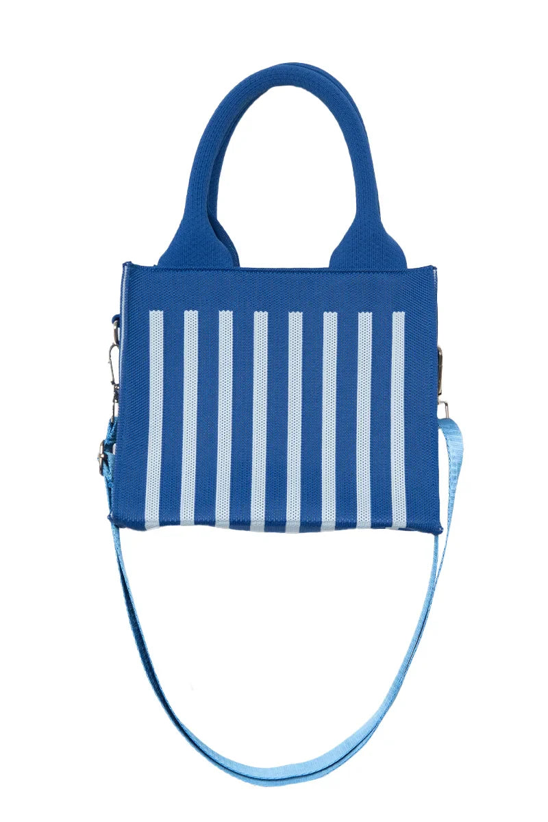 The Katydid Blue Striped Mini Tote Handbag is a cute everyday bag with two handles, vertical light blue stripes on the front, and a detachable light blue shoulder strap.