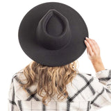 the back of a woman wearing a women’s black felt hat